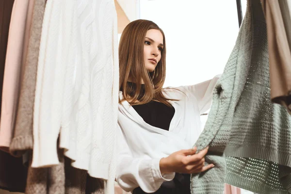 Attractive girl choosing clothes — Stock Photo