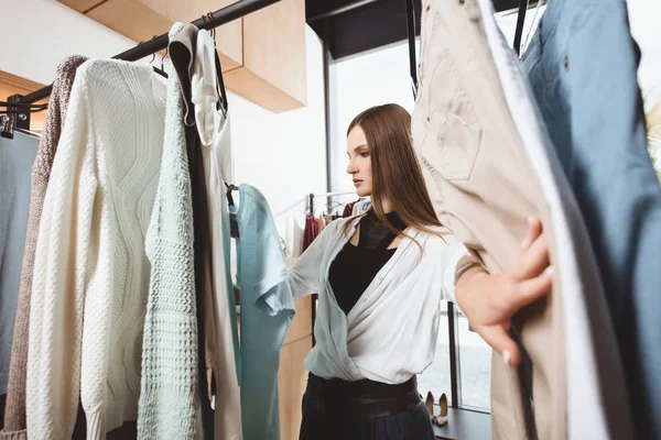 Девушка выбирает одежду в бутике — стоковое фото