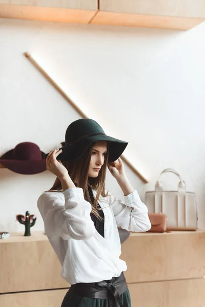 Femme choisissant chapeau en boutique — Photo de stock