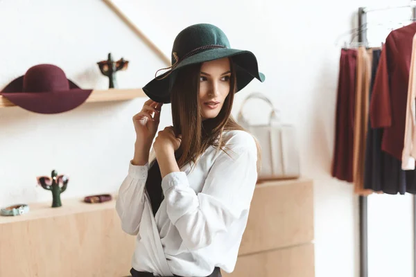 Mujer eligiendo sombrero - foto de stock
