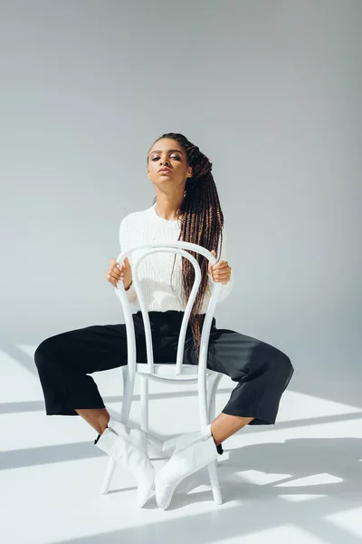Chica afroamericana de moda con silla - foto de stock