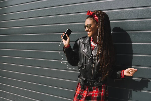 Chica afroamericana con estilo con teléfono inteligente - foto de stock