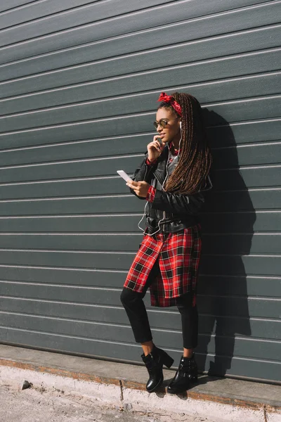 Chica afroamericana con estilo con teléfono inteligente - foto de stock