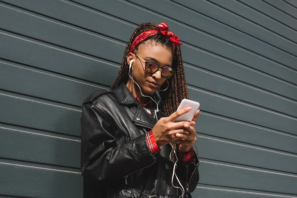 Chica afroamericana con estilo con teléfono inteligente - foto de stock