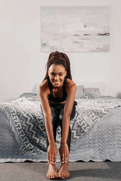 Жінка в спортивному одязі сидить на ліжку — стокове фото
