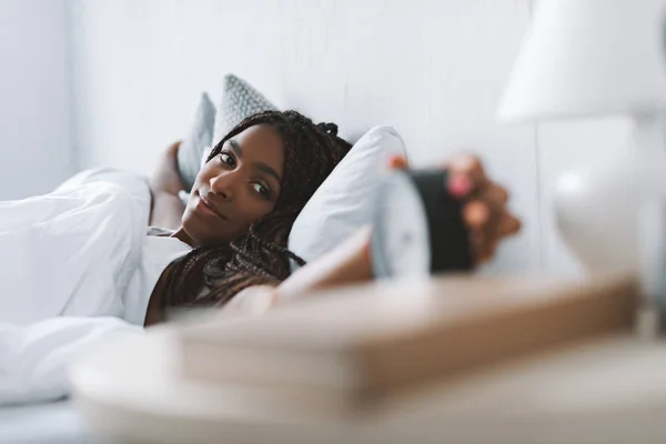 Mujer apagando despertador - foto de stock