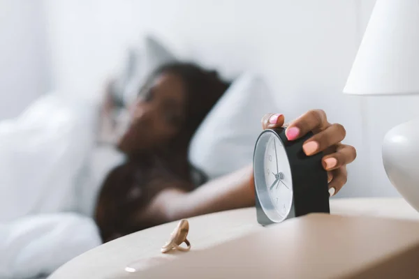 Mujer apagando despertador - foto de stock