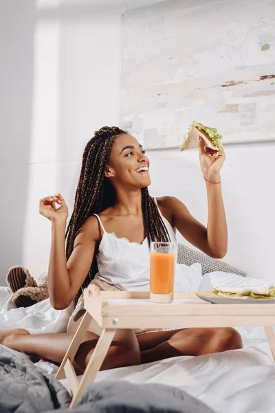 Жінка їсть сніданок у ліжку — стокове фото