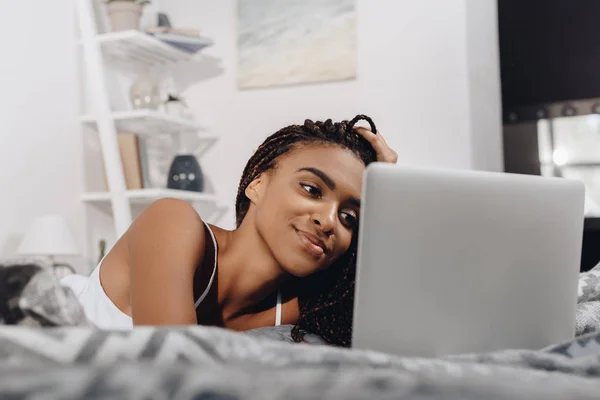 Mujer usando portátil en la cama - foto de stock
