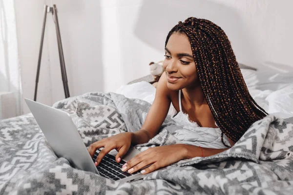 Frau benutzt Laptop im Bett — Stockfoto