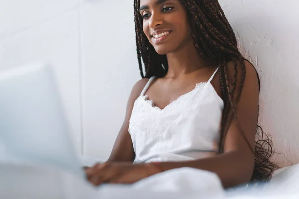 Femme utilisant un ordinateur portable au lit — Photo de stock