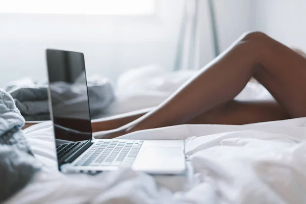 Femme au lit avec ordinateur portable — Photo de stock
