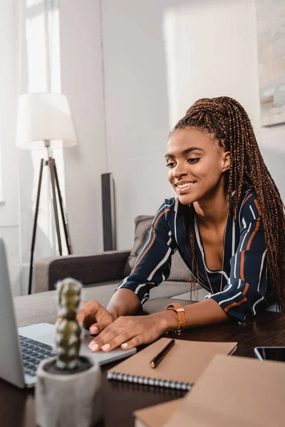 Woman using laptop on couch — Stock Photo