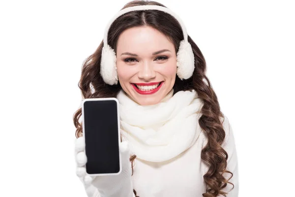Donna in paraorecchie e sciarpa mostrando smartphone — Foto stock