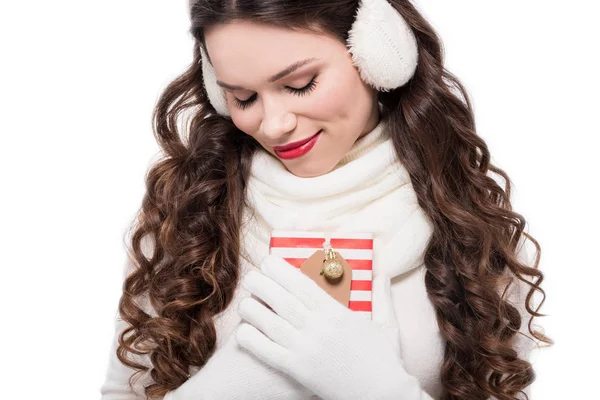 Woman in earmuffs and scarf holding present — Stock Photo