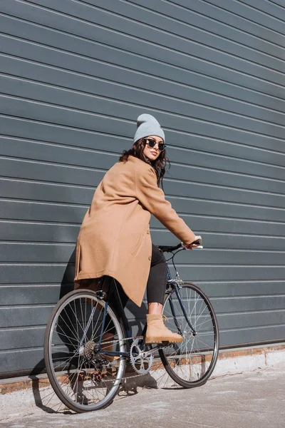 Женщина в осеннем наряде сидит на велосипеде — стоковое фото