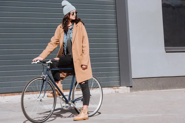 Mujer en traje de otoño sentado en bicicleta - foto de stock