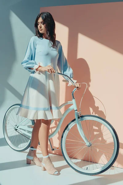 Женщина в модном бирюзовом платье с велосипедом — стоковое фото