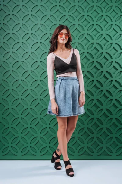 Mulher de saia jeans e óculos de sol laranja — Fotografia de Stock