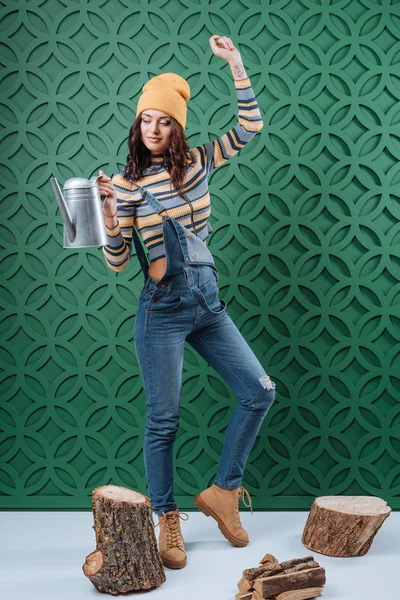 Woman in autumn outfit with watering can — Stock Photo