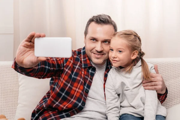 Отец и дочь с помощью смартфона — стоковое фото