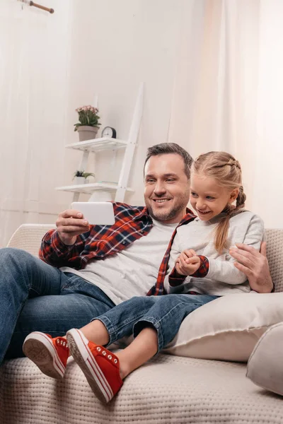 Padre e hija usando smartphone - foto de stock