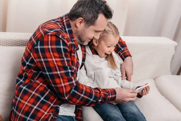 Padre e hija usando smartphone - foto de stock