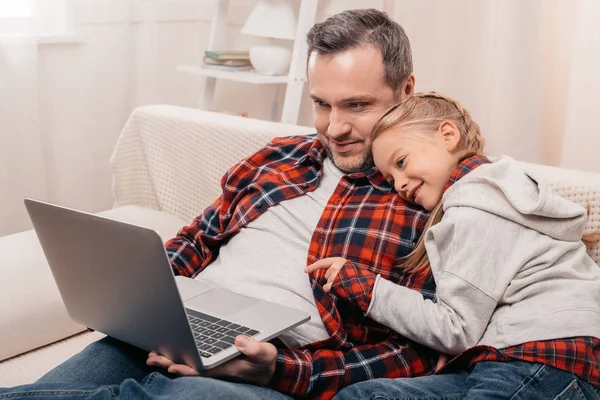 Padre e hija usando laptop - foto de stock