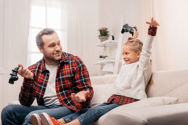 Père et fille jouant avec des joysticks — Photo de stock