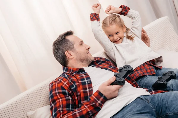 Père et fille jouant avec des joysticks — Photo de stock