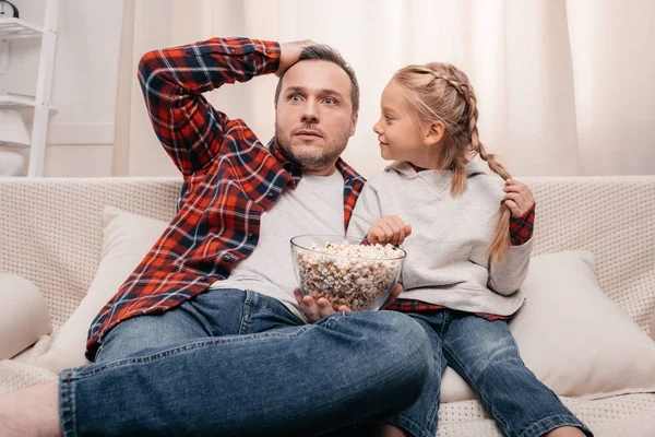 Father and daughter eating popcorn — Stock Photo