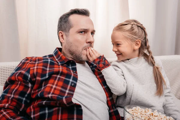 Pai e filha comendo pipocas — Fotografia de Stock