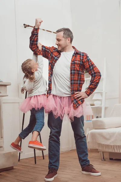 Padre e hija en faldas rosadas - foto de stock