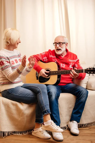 Senior man playing on guitar for wife — Stock Photo