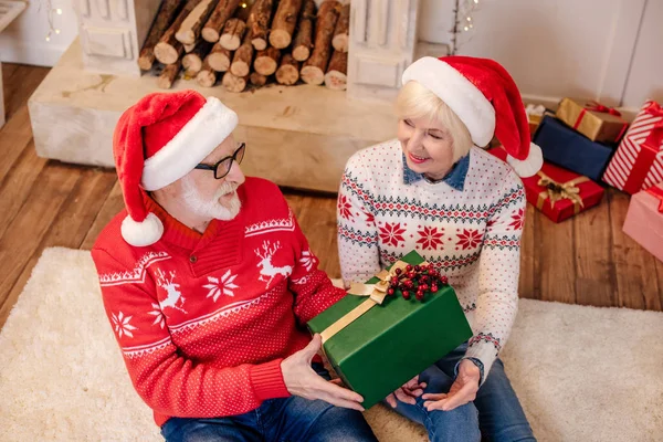 Senior couple with christmas present — Stock Photo