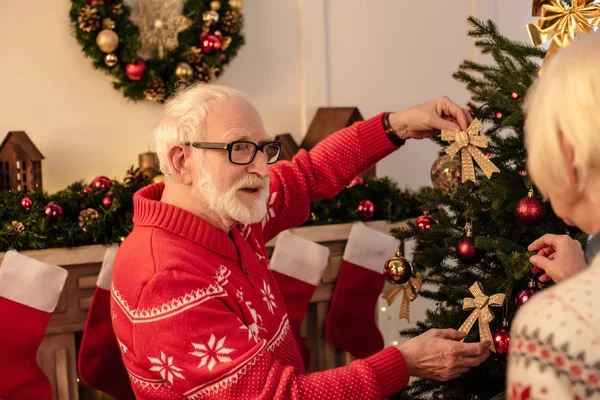Seniorenpaar schmückt Weihnachtsbaum — Stockfoto