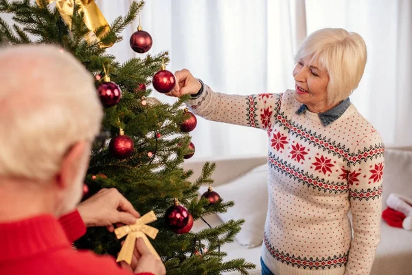 Seniorenpaar schmückt Weihnachtsbaum — Stockfoto