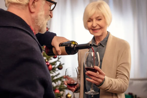 Couple sénior avec du vin à Noël — Photo de stock