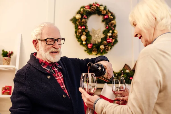 Pareja de ancianos con vino en Navidad - foto de stock