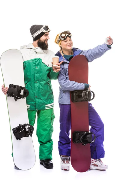 Pareja con tablas de snowboard tomando selfie - foto de stock