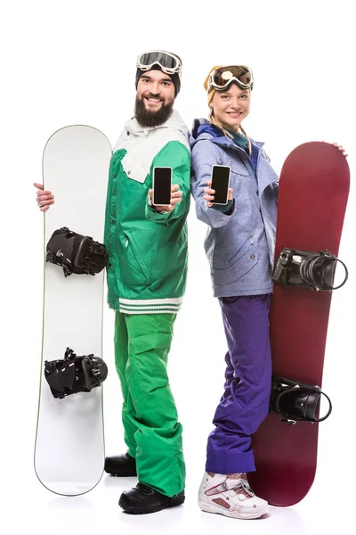 Smiling snowboarders with smartphones — Stock Photo