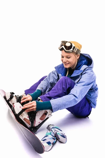 Mujer atando equipo de snowboard - foto de stock