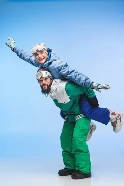 Par de snowboarders piggybacking juntos — Fotografia de Stock