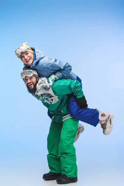 Par de snowboarders piggybacking juntos — Fotografia de Stock