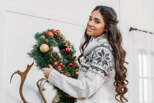 Femme tenant une couronne de Noël — Photo de stock