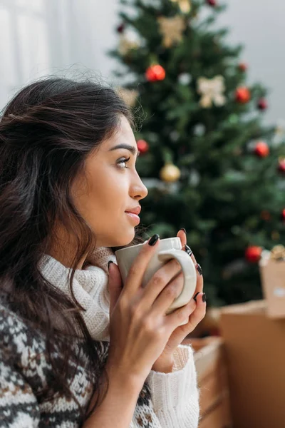 Mujer con taza de bebida caliente en Navidad - foto de stock