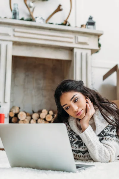 Mujer en suéter caliente trabajando con el ordenador portátil - foto de stock