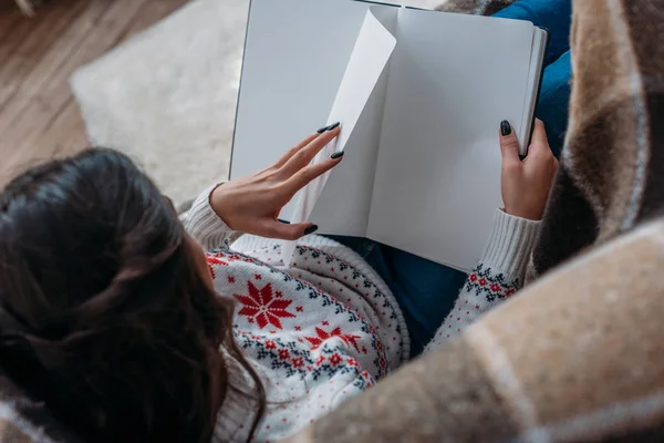 Frau liest Buch im Sessel — Stockfoto