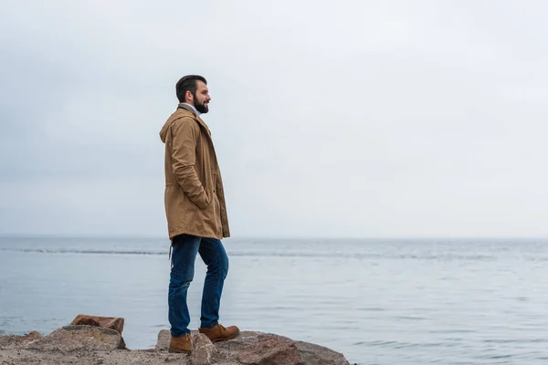 Hombre de pie en la orilla del mar - foto de stock