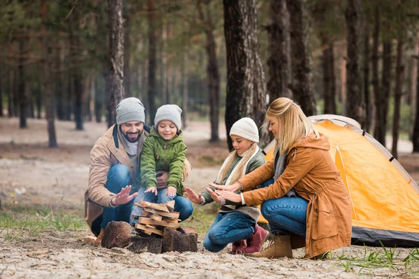 Familia calentando manos con hoguera — Stock Photo